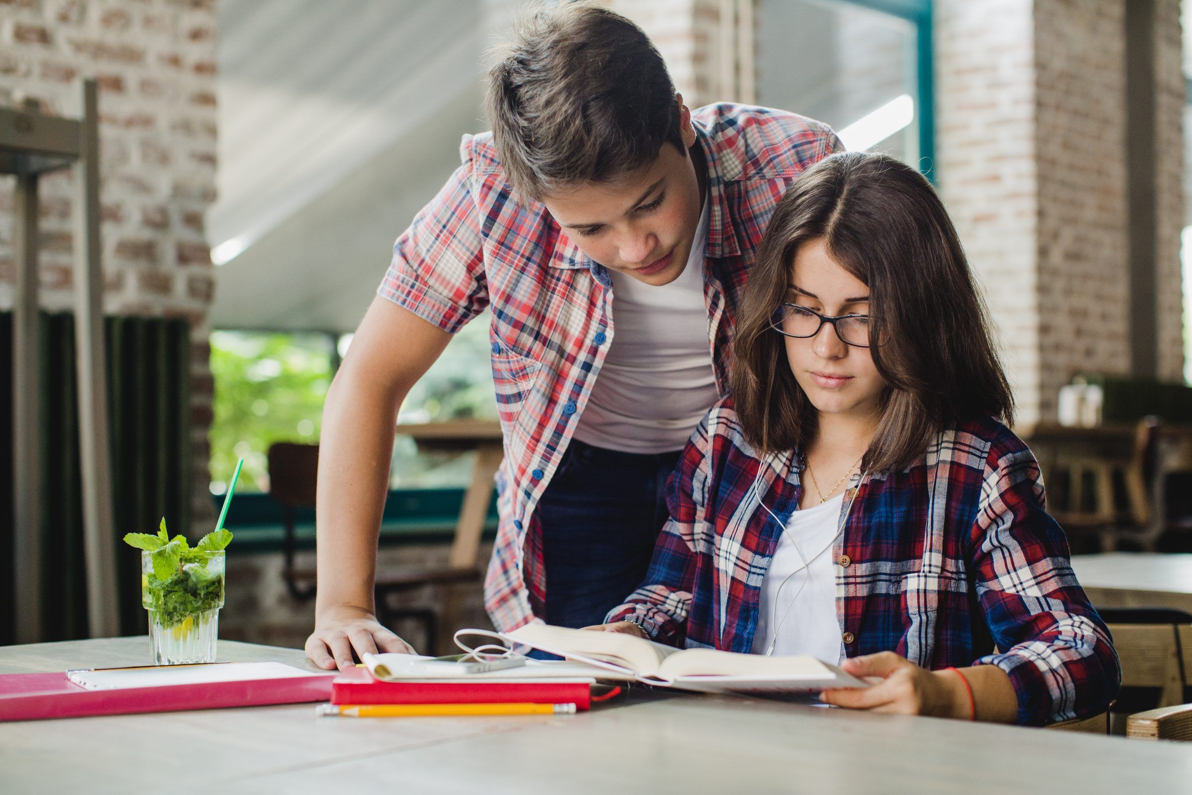 Dos estudiantes resolviendo ejercicios juntos en una mesa